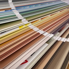 Paleta kolorów farb ułożona warstwami, prezentująca szeroki wybór odcieni brązu, beżu, zieleni i błękitu, z delikatnym efektem głębi ostrości.