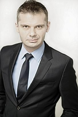 Portret biznesowy mężczyzny w garniturze, wykonany w Warszawie. Ostry kontur włosów i subtelne cieniowanie twarzy podkreślają profesjonalny wizerunek.