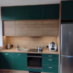 Nowoczesna kuchnia z ciemnozielonymi szafkami dolnymi i drewnopodobnymi górnymi, srebrna lodówka w zabudowie, na blacie czajnik, robot kuchenny i garnek na płycie.