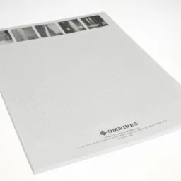 Notatnik firmowy z siatką w tle i logo OMNIRES w dolnej części, prezentujący adres i dane kontaktowe firmy.