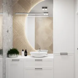 Nowoczesna łazienka z okrągłym lustrem podświetlonym LED, białą umywalką nablatową i szafką z czarnymi uchwytami, akcentem roślinnym i ścianą z dekoracyjną fakturą.