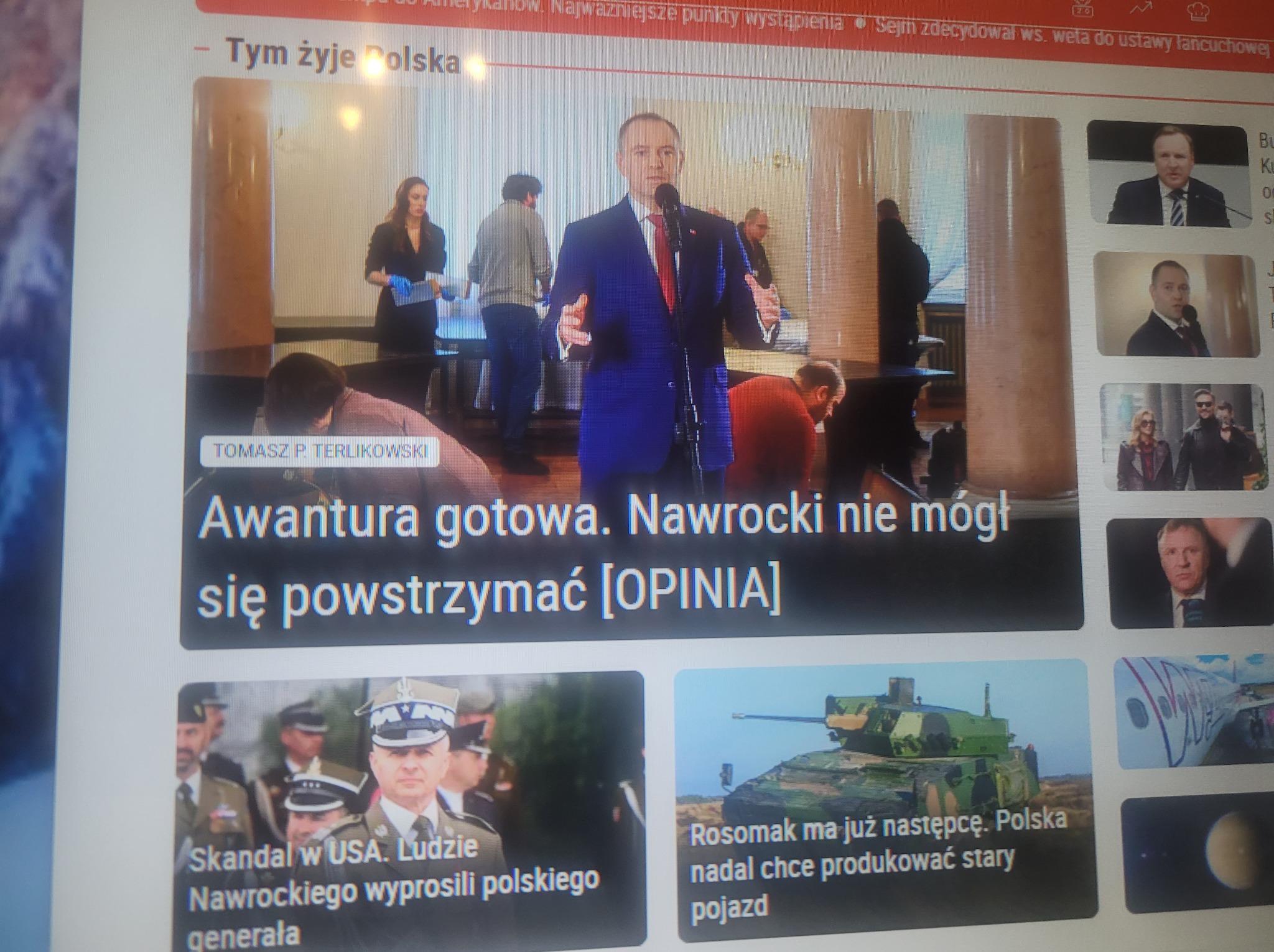 Ekran komputera z otwartą stroną internetową, na której widoczne są artykuły prasowe i zdjęcia, w tym polityk przemawiający do mikrofonu.