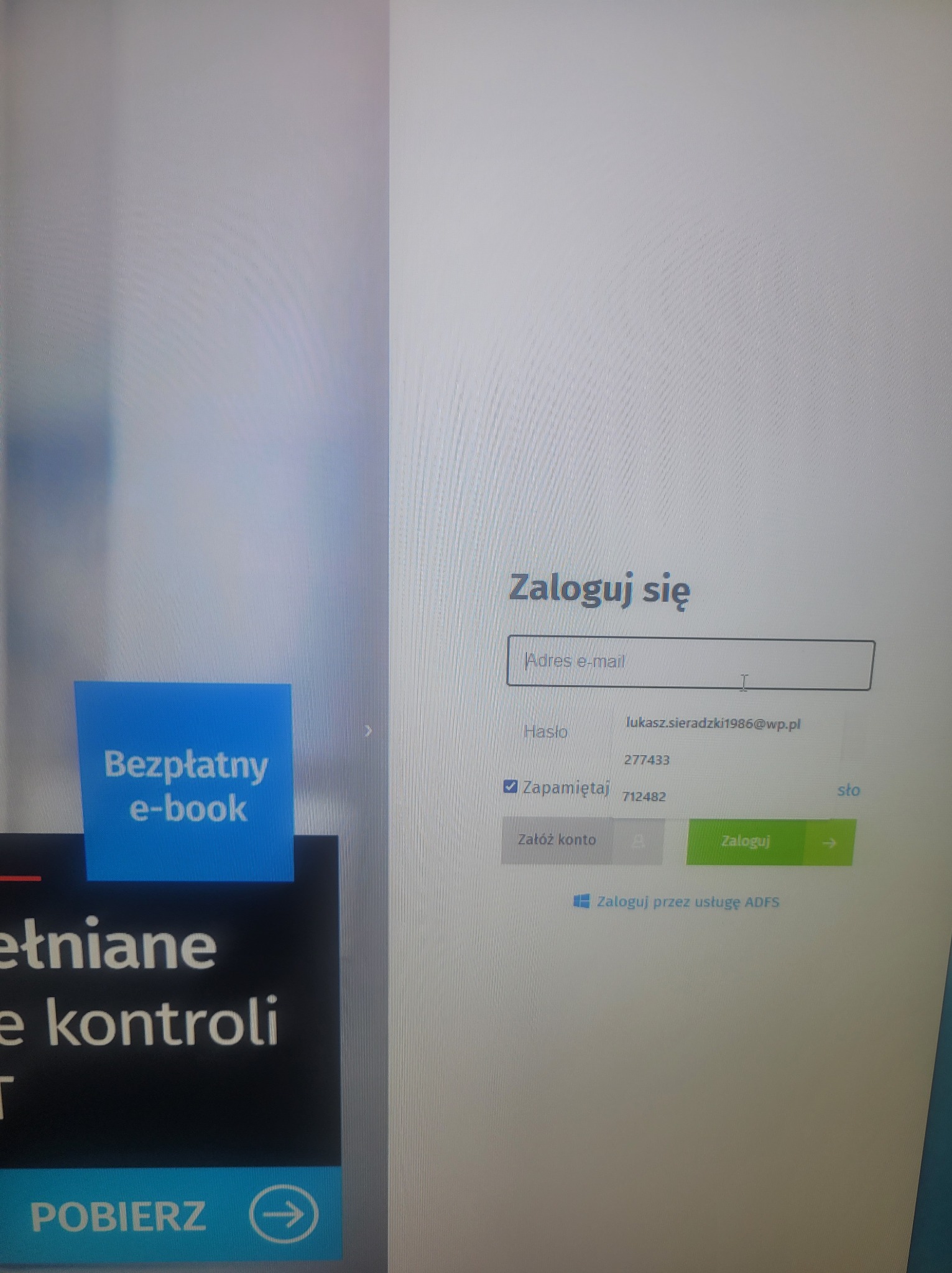 Ekran logowania z polem na adres e-mail, hasło i przyciskiem 'Zaloguj'. Widoczny fragment reklamy 'Bezpłatny e-book'.