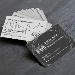 Wizytówki firmy Elektromato Mateusz Janeczko, oferującej usługi ogólnobudowlane i instalacje elektryczne, ułożone wachlarzowo na szarym tle.