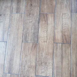 Ułożone panele podłogowe imitujące drewno, widoczne fugi i wzór słojów.