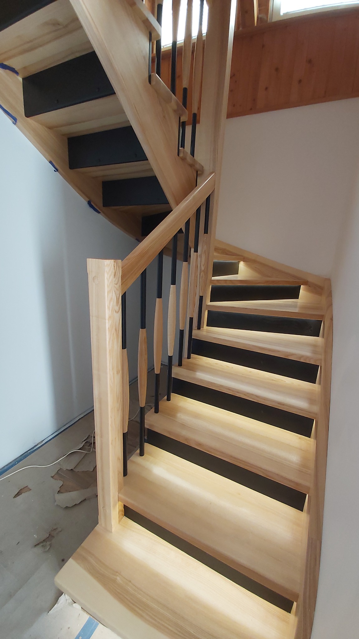 Schody jesionowe podstopnie czarny MDF podświetlenie stopni balustrada tralki okrągłe drewno metal.