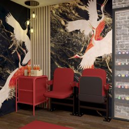 Mikab Studio. Projektowanie Wnętrz. Magdalena Mizia - Wnętrze z tapetą w motywie żurawi, czerwonymi fotelami kinowymi, stolikiem z napojami Coca-Cola i oświetleniem wiszącym w stylu industrialnym.