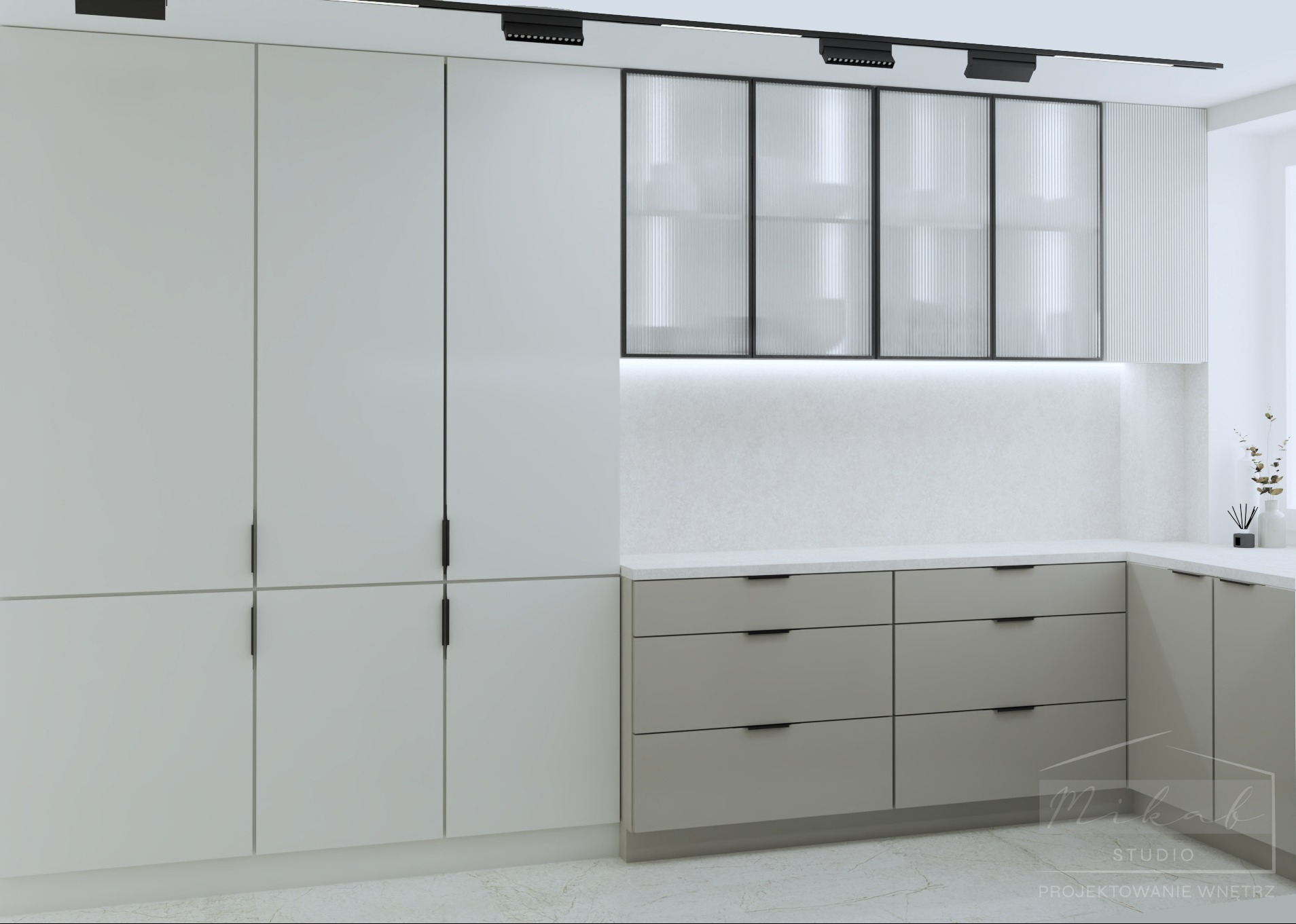 Minimalistyczna kuchnia z białymi szafkami, szarymi szufladami i ryflowanymi szklanymi witrynami podświetlonymi od dołu, oświetlenie szynowe na suficie.