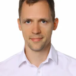 Portret mężczyzny w białej koszuli z kołnierzykiem na białym tle.