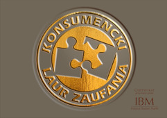 Złoty certyfikat 'Konsumencki Laur Zaufania' z dwoma szarymi puzzlami w środku, umieszczony na szarym tle.