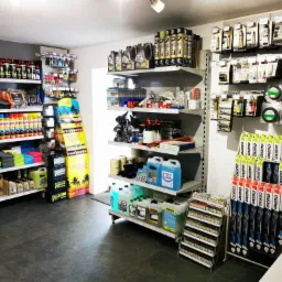 Wnętrze sklepu z artykułami motoryzacyjnymi i samochodowymi, regały wypełnione płynami eksploatacyjnymi, kosmetykami samochodowymi, wycieraczkami, olejami silnikowymi i innymi akcesoriami.