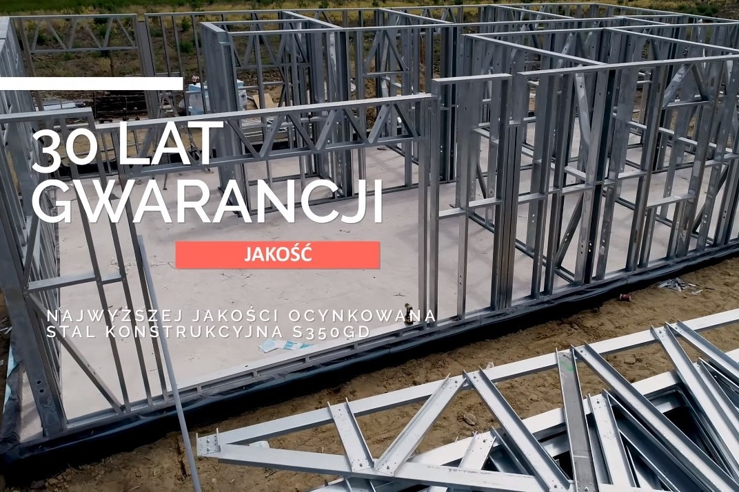 Konstrukcja szkieletowa domu w trakcie budowy, stal ocynkowana S350GD, widoczny napis '30 LAT GWARANCJI JAKOŚĆ' nałożony na zdjęcie.