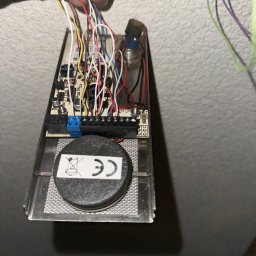 Instal-Tech Szymon Waszak - Otwarta obudowa czujnika alarmowego z widoczną elektroniką, podłączonymi przewodami i elementami montażowymi. Widoczne oznaczenia CE na elemencie czujnika.