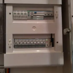 Rozdzielnica elektryczna z zabezpieczeniami przepięciowymi i modułem sterującym Zamel ROM-10, widoczne bezpieczniki Hager i oznaczenia Elektro-Plast.