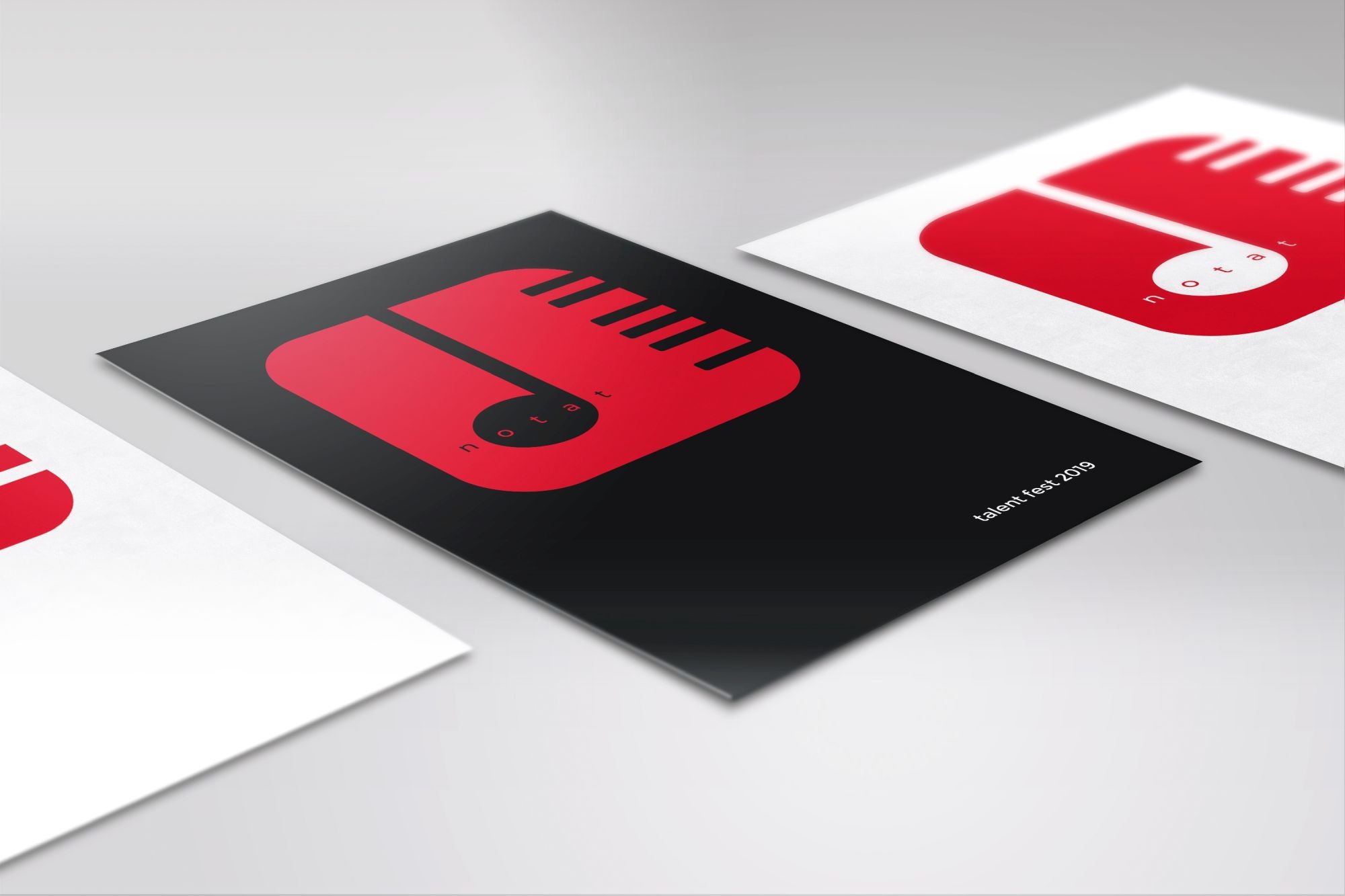 Trzy ulotki z minimalistycznym, czerwono-czarnym logo mikrofonu i napisem 'talent fest 2019', ułożone pod kątem na jasnym tle.