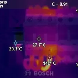 Termowizyjne zdjęcie rozdzielnicy elektrycznej Bosch, wskazujące temperaturę poszczególnych elementów, z datą i godziną wykonania pomiaru.