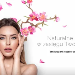 Portret kobiety z dłońmi przy twarzy, akwarelowe gałązki kwitnącej wiśni w tle, napis 'Naturalne piękno w zasięgu Twojej ręki'.