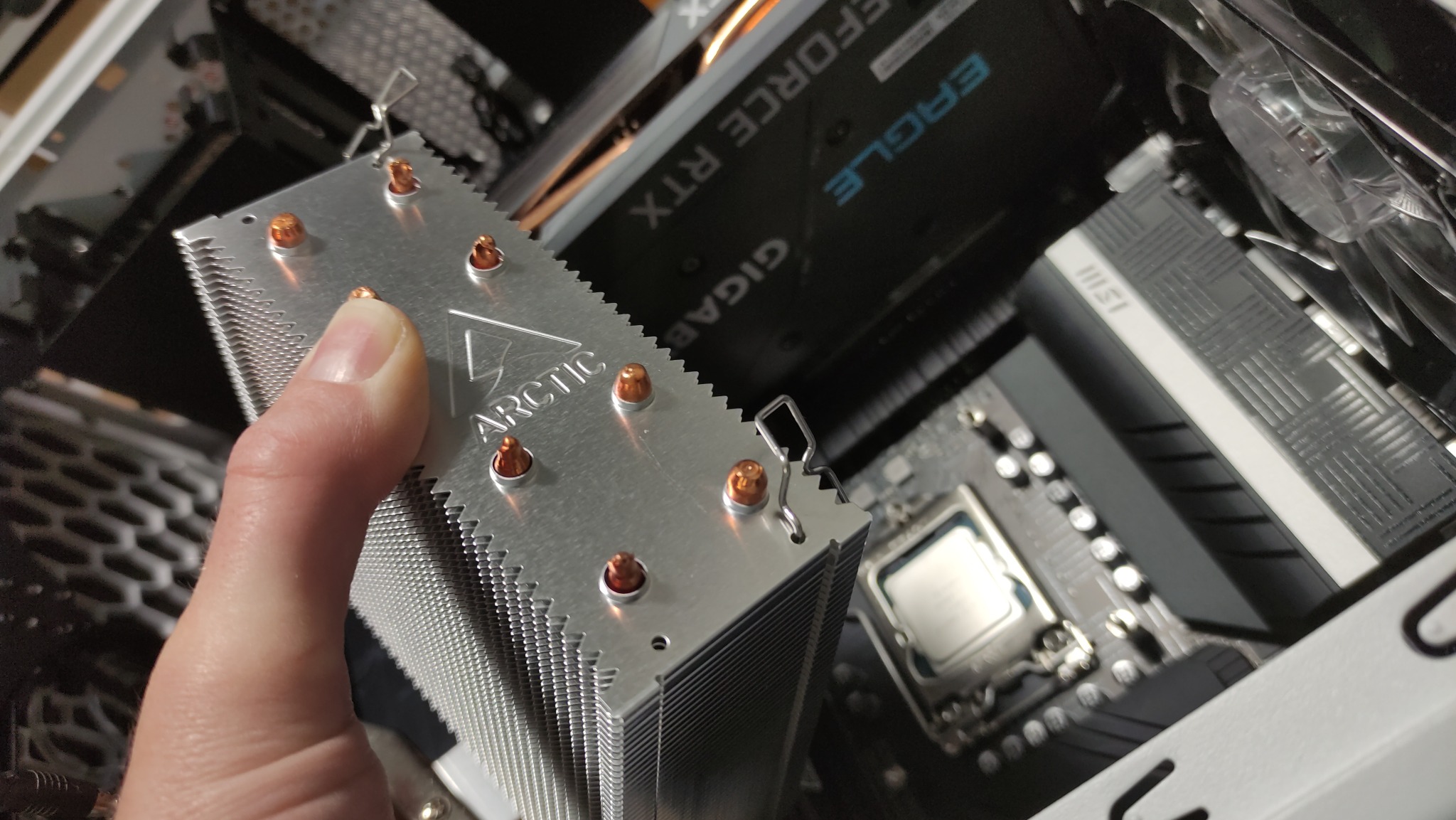 Instalacja chłodzenia procesora Arctic w komputerze stacjonarnym w Józefowie, widoczna karta graficzna Gigabyte Eagle RTX i płyta główna MSI.