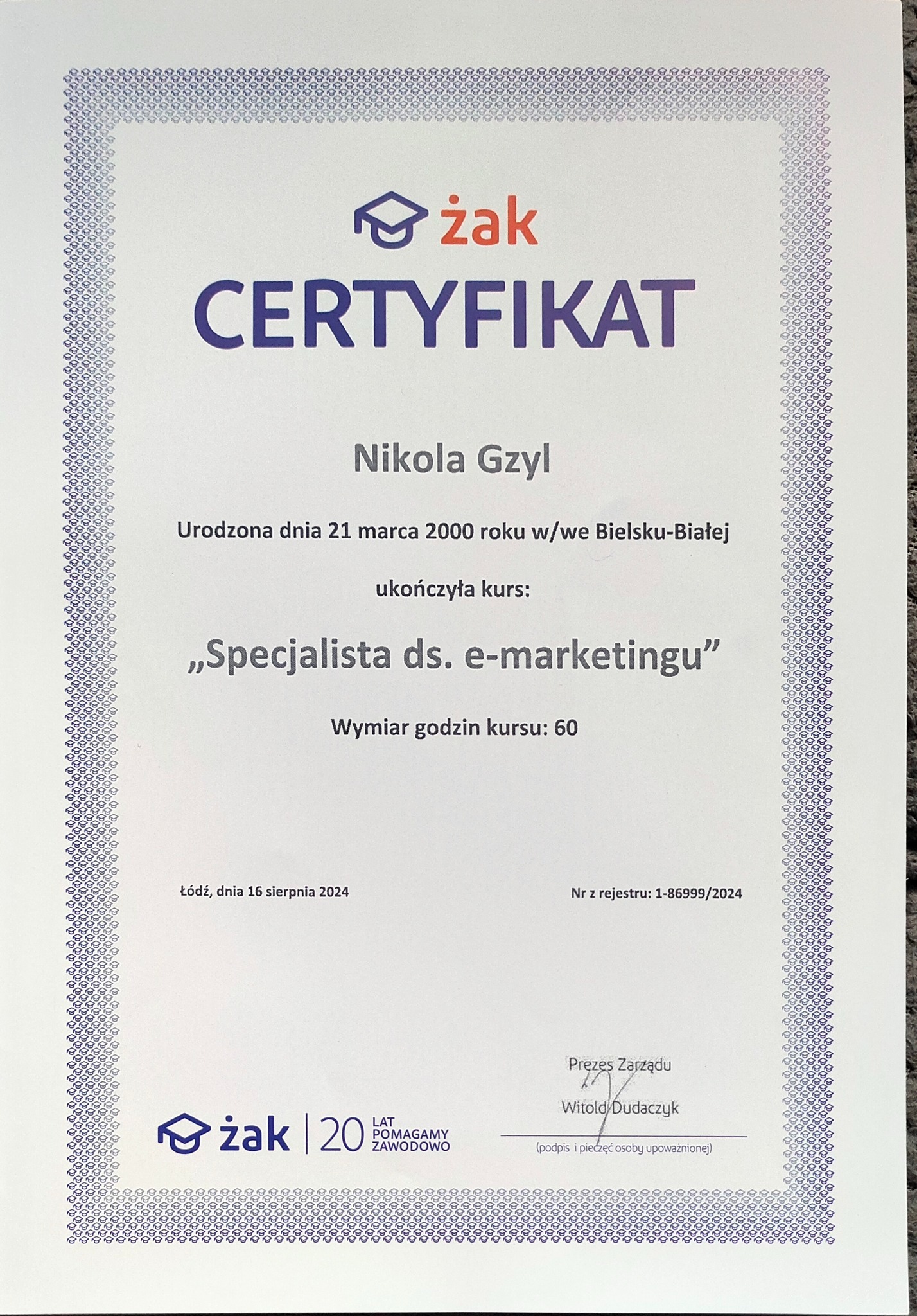 Certyfikat ukończenia kursu 'Specjalista ds. e-marketingu' dla Nikoli Gzyl, wydany przez Żak, z datą 16 sierpnia 2024. Dokument z ozdobną ramką.