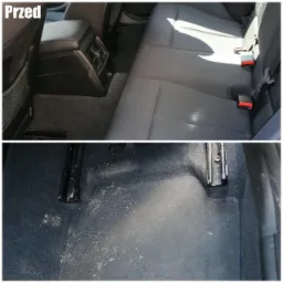 Zdjęcie typu 'przed' przedstawia bardzo zabrudzone wnętrze samochodu: tylna kanapa i podłoga pokryte piaskiem i okruchami. Widoczne zaczepy pasów bezpieczeństwa i szyny foteli.