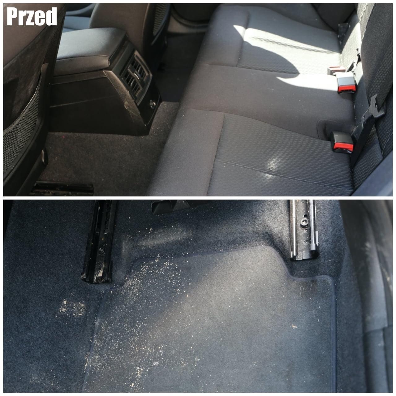 Zdjęcie typu 'przed' przedstawia bardzo zabrudzone wnętrze samochodu: tylna kanapa i podłoga pokryte piaskiem i okruchami. Widoczne zaczepy pasów bezpieczeństwa i szyny foteli.