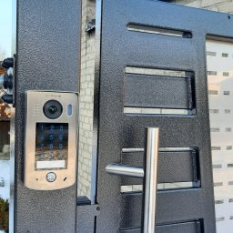 Electro Zych - Nowoczesny wideodomofon Vidos zamontowany na metalowej bramie posesji z widocznym panelem numerycznym i kamerą.
