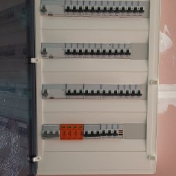 Electro Zych - Otwarta skrzynka rozdzielcza z bezpiecznikami i ogranicznikiem przepięć na ścianie w trakcie wykańczania.