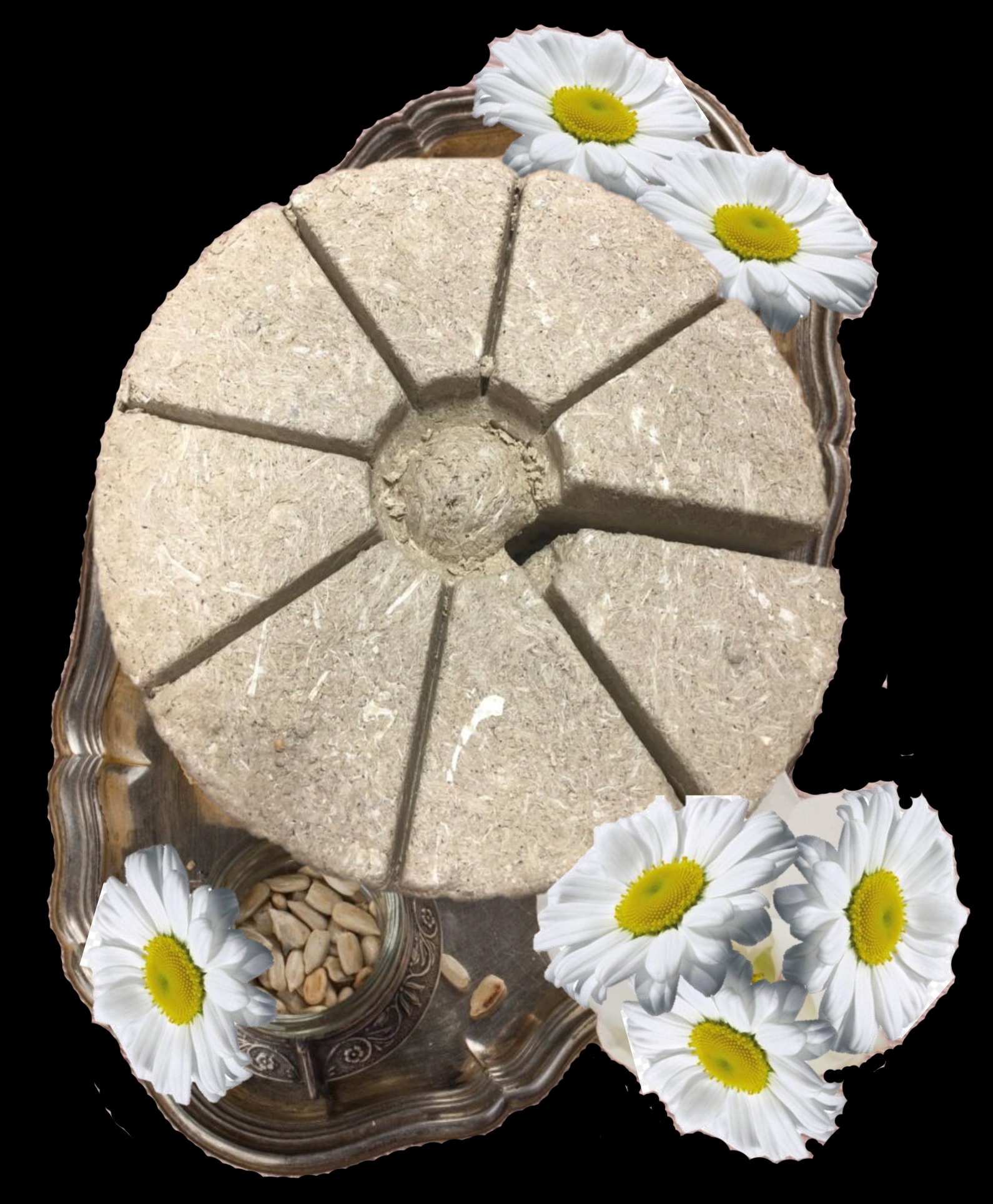 Okrągła chałwa pokrojona na porcje, ułożona na srebrnej tacy z dekoracją z białych kwiatów i słoiczkiem nasion słonecznika.