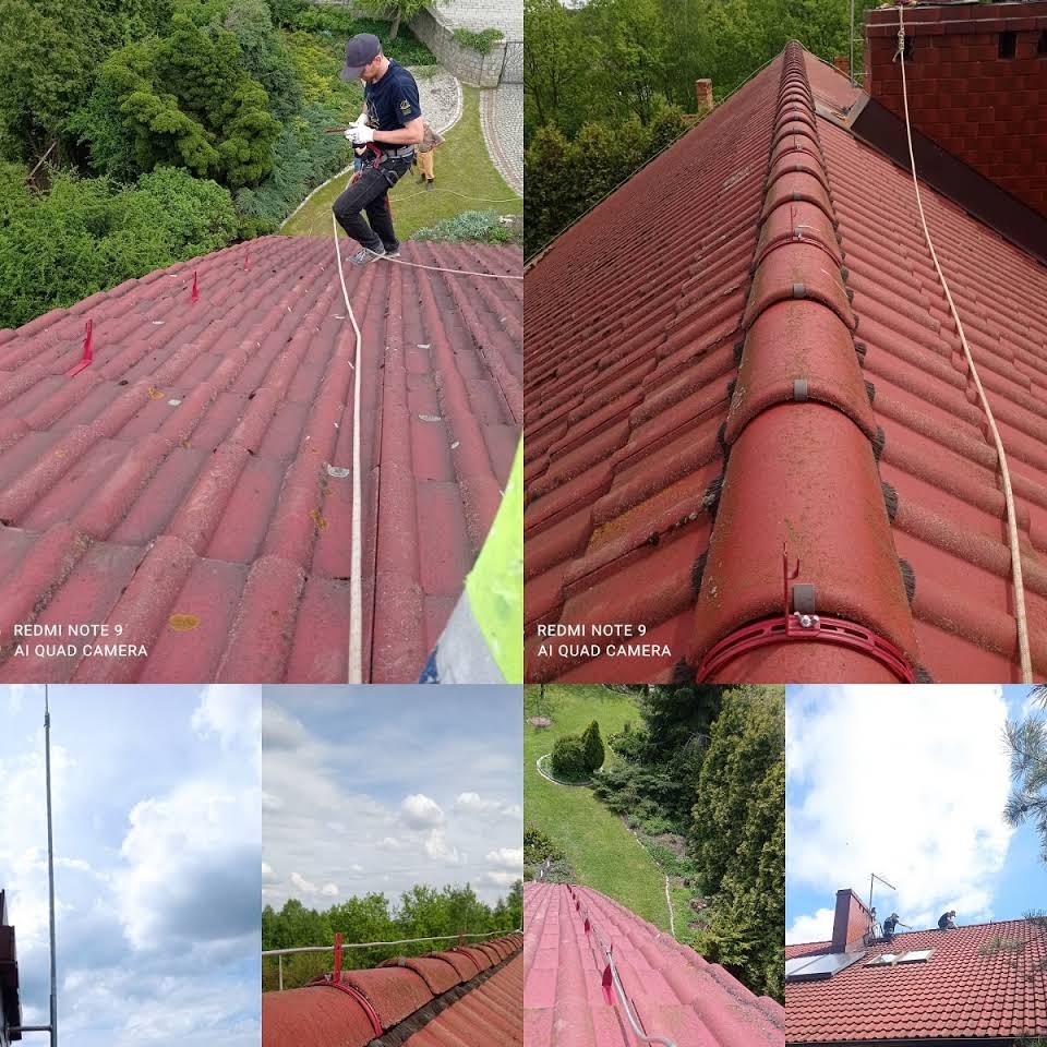 Praca na dachu z czerwonej dachówki: mężczyzna w kasku i uprzęży zabezpieczającej, stojący na dachu z liną, drugi pracownik na ziemi, widoczna instalacja odgromowa z uchwytami. Część zdjęcia...