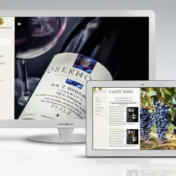 Prezentacja strony internetowej firmy Oberhofer na monitorze i tablecie, z widocznym menu, butelką soku winogronowego i zdjęciem winogron.