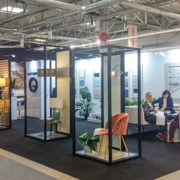 Brand Creation Sp.j - Aranżacja stoiska targowego z ekspozycją łazienek i elementów wyposażenia wnętrz, w tym umywalki, armatura, oświetlenie i płytki ceramiczne, z widocznymi osobami w tle.