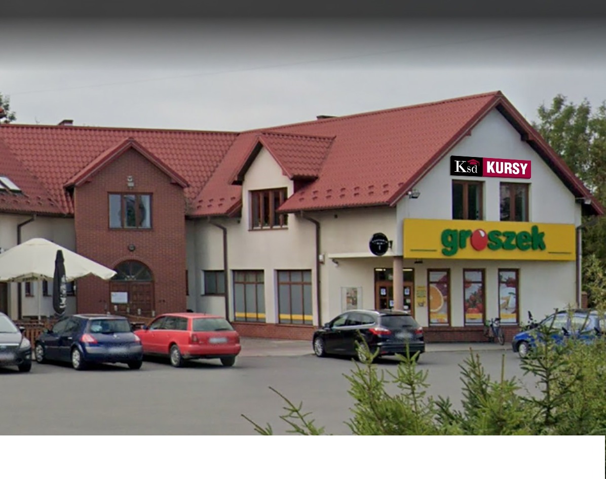 Budynek sklepu spożywczego Groszek z dopisanym logotypem 'Ksd Kursy' na elewacji, zaparkowane samochody na parkingu przed budynkiem.