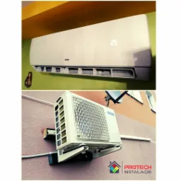 Dwu-częściowy klimatyzator AUX: jednostka wewnętrzna zamontowana na zielonej ścianie z wyświetlaczem temperatury 25 stopni, oraz jednostka zewnętrzna przymocowana do ściany budynku z widoczną...