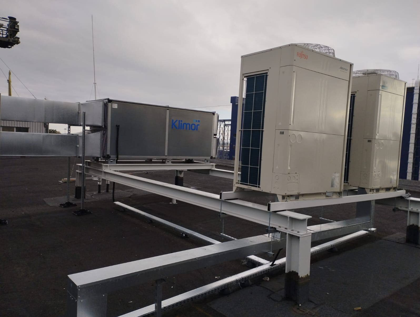 Instalacja wentylacyjna Klimor i dwa agregaty klimatyzacyjne Fujitsu Airstage na dachu budynku, zamontowane na metalowej konstrukcji wsporczej.