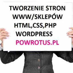 Osoba w garniturze trzyma białą tablicę z napisem 'Tworzenie stron WWW/Sklepów HTML, CSS, PHP WordPress POWROTUS.PL' na białym tle.
