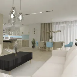 Jasne, przestronne wnętrze mieszkania z otwartą kuchnią, jadalnią i salonem. Widoczny biały narożnik, czarny stolik kawowy z dekoracyjnym wazonem, stół z krzesłami w odcieniach beżu i błękitu...