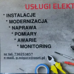 Ujęcie z bliska wizytówki usług elektrycznych z wykazem usług: instalacje, modernizacja, naprawa, pomiary, awarie, monitoring, numer telefonu i adres e-mail, obok widoczne narzędzia: miernik...