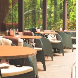 C3SOLUTIONS Kamil Puchała - Ekran logowania do aplikacji z widokiem na ogródek restauracyjny z okrągłymi stolikami, rattanowymi krzesłami i pledami.