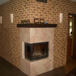 Wnętrze pokoju z kominkiem obudowanym marmurem, ściany wykończone cegłą klinkierową, na kominku dekoracje i oświetlenie ścienne.