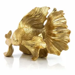 Złota, metaliczna figurka ryby bojownika syjamskiego z rozłożystymi płetwami, ustawiona na białym, błyszczącym podłożu, rzucająca wyraźne odbicie.