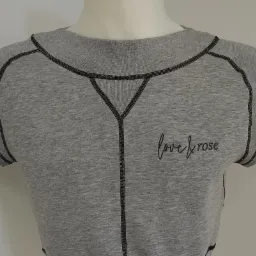 Szara bluzka damska z krótkim rękawem i czarnymi przeszyciami oraz haftowanym napisem 'love & rose' na manekinie.