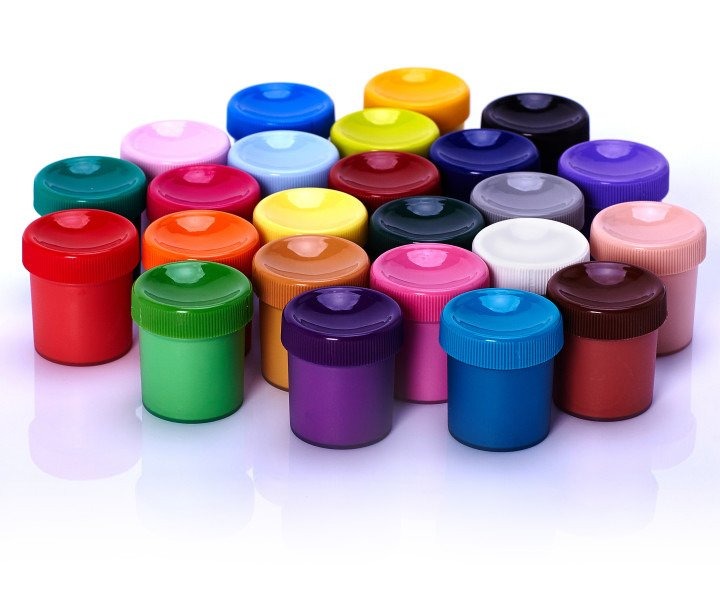 Kolekcja małych pojemników z farbami w różnych odcieniach, ułożonych blisko siebie na białym tle, tworzących paletę barw.