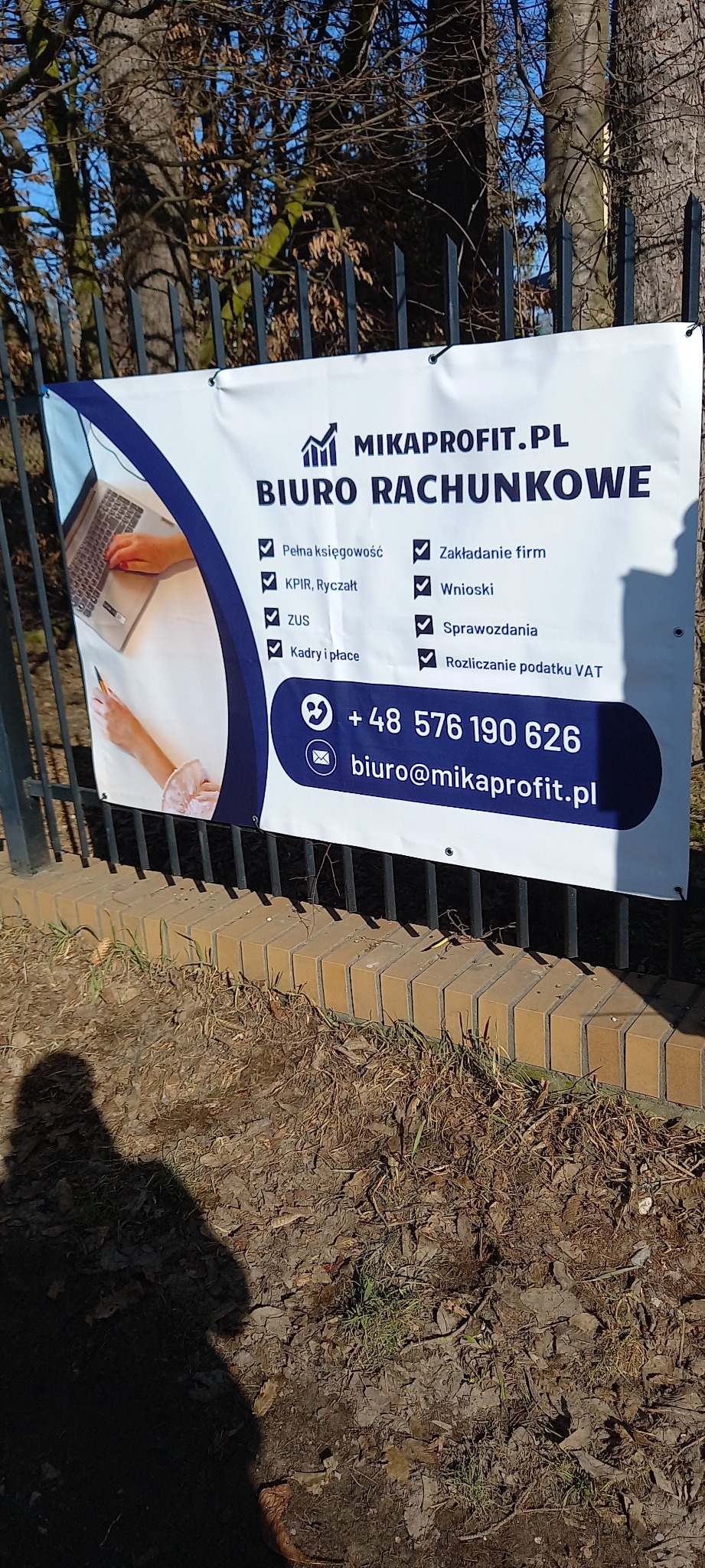 Baner Biura Rachunkowego MIKA PROFIT z Lublina, wiszący na ogrodzeniu. Oferuje pełną księgowość, kadry i płace, rozliczanie VAT, wnioski i sprawozdania. Kontakt: biuro@mikaprofit.pl.