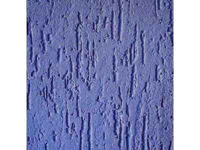 Niebieska ściana pokryta tynkiem żywicznym o wyraźnej, rowkowej fakturze, z pionowymi, nieregularnymi wgłębieniami.