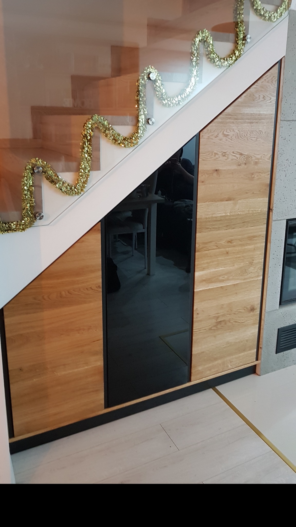 Naturalne drewno dębowe w czarnym wykończeniu. Komoda i zabudowa pod schodami.