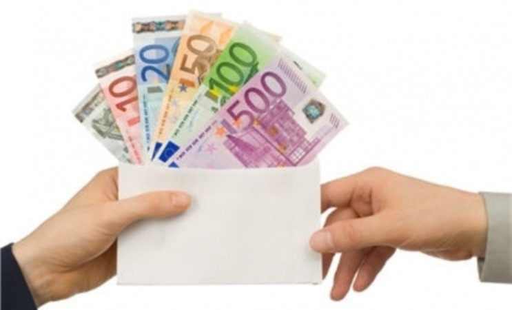 Dwie ręce trzymają białą kopertę wypełnioną różnymi nominałami banknotów euro, od 10 do 500 euro, na białym tle.