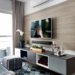 Nowoczesny salon w Łaziskach Górnych z zamontowaną klimatyzacją na ścianie nad telewizorem, minimalistyczny design, drewniane panele ścienne.