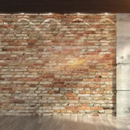 Wnętrze z surową czerwoną cegłą, betonowymi panelami po bokach i drewnianą podłogą, oświetlone punktowymi lampami sufitowymi.