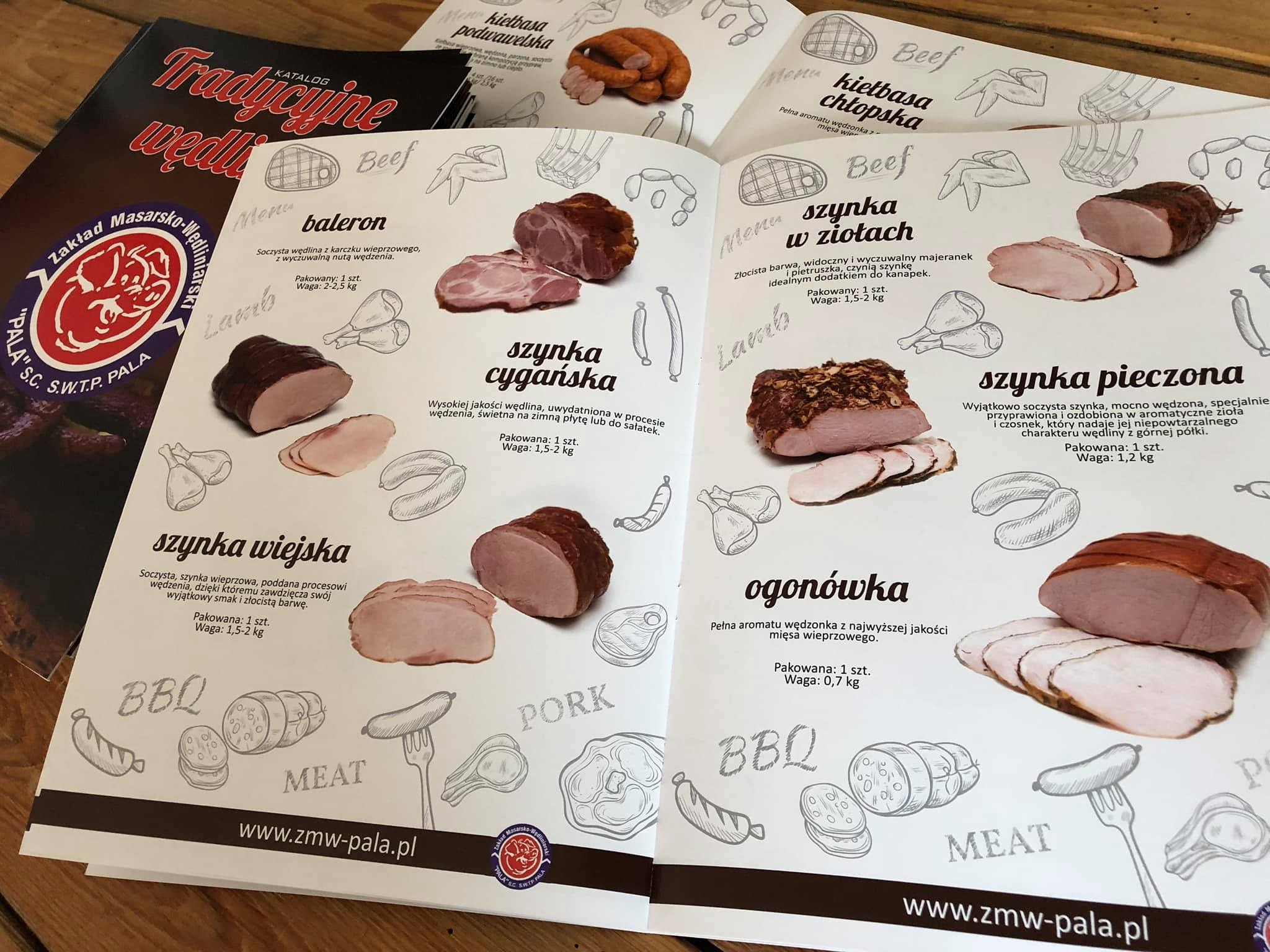 Otwarty katalog z ilustracjami i opisami wędlin, leżący na drewnianym stole obok zamkniętego katalogu z logo Zakładu Masarsko-Wędliniarskiego 'PALA'.
