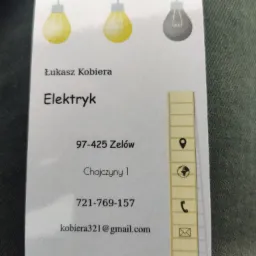 Wizyt&oacute;wka elektryka Łukasza Kobiery z trzema żar&oacute;wkami w logo, danymi kontaktowymi i adresem.